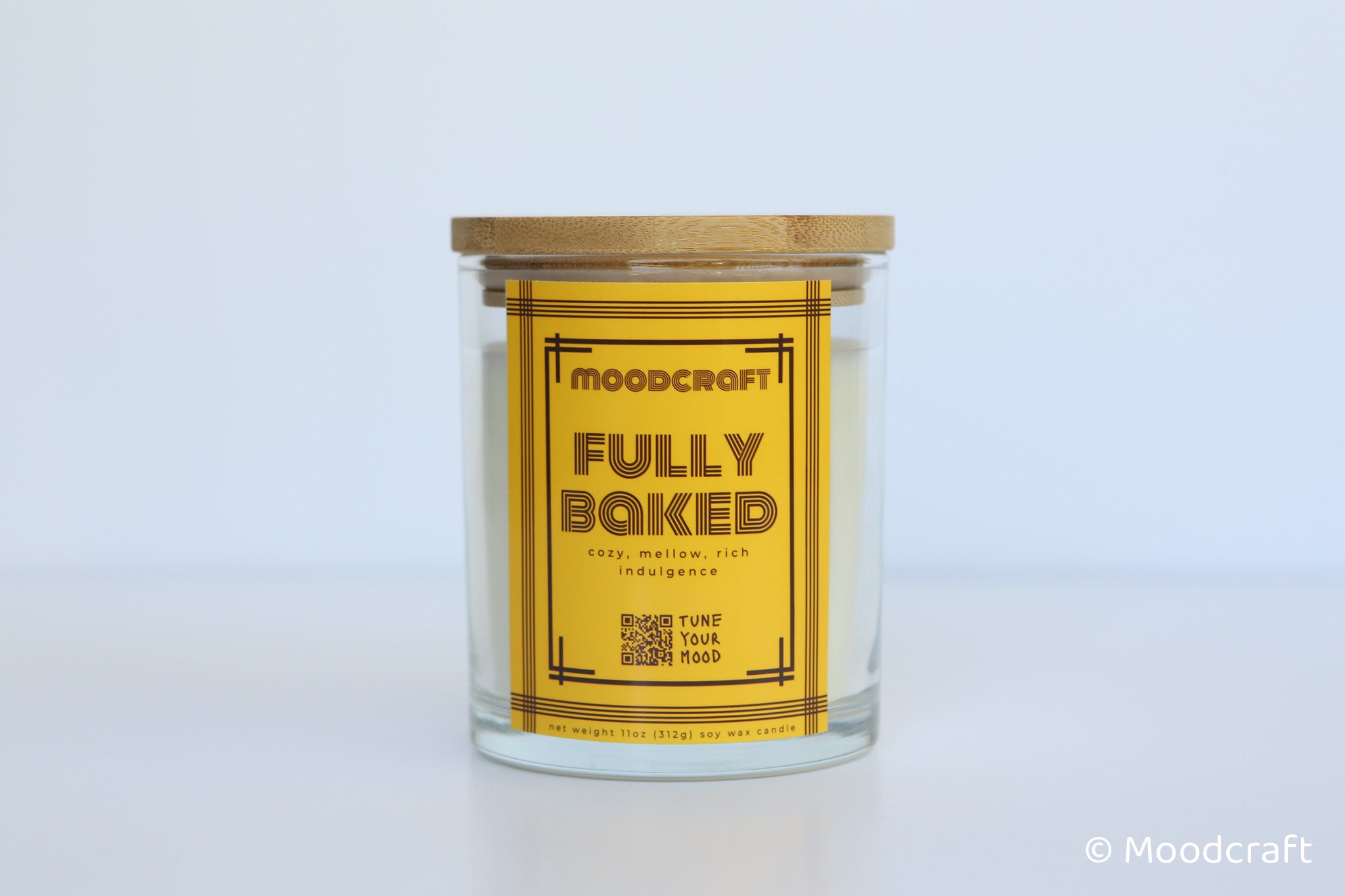 Moodcraft candle with a wooden lid on a light gray background
