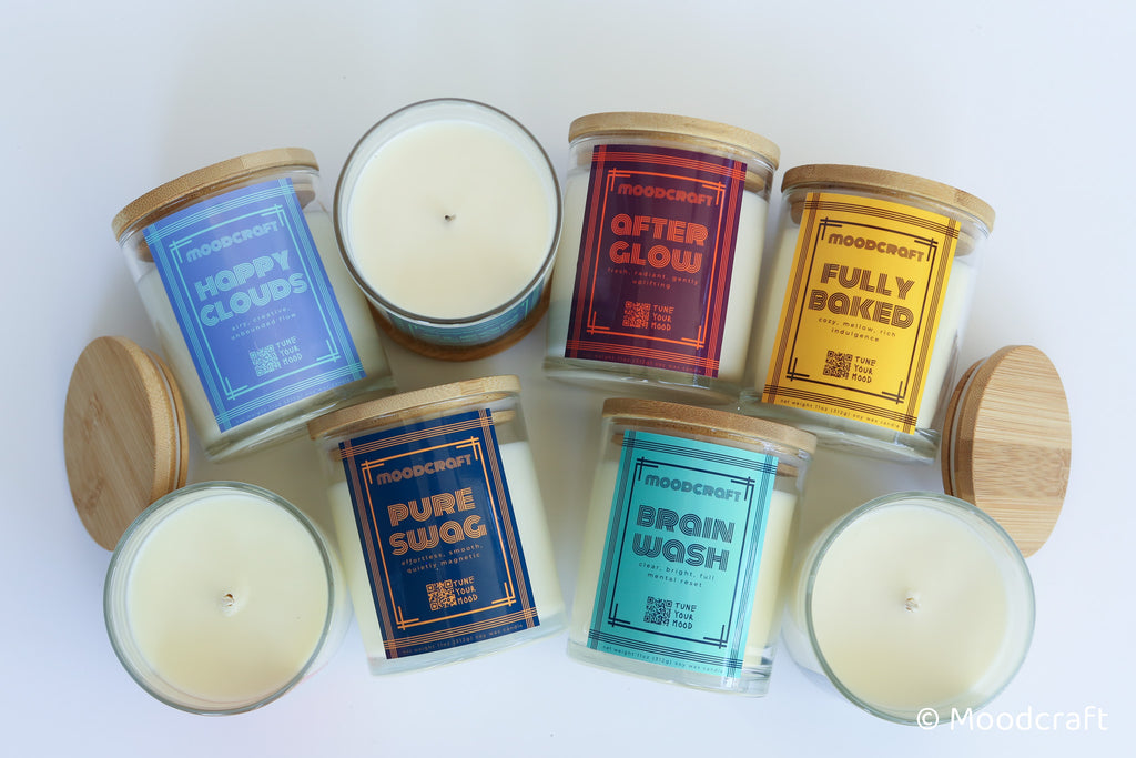 Collection of scented candles with labeled lids on a white background