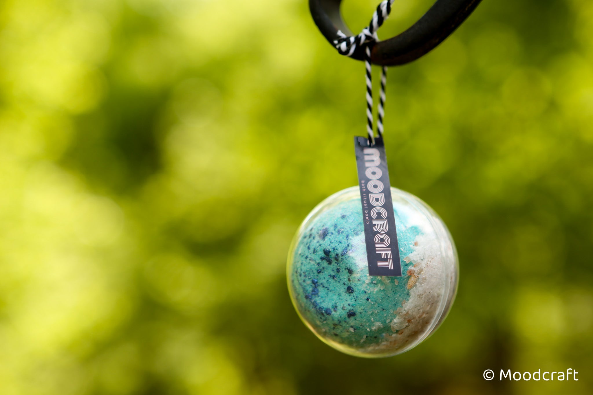 Moodcraft pendant with a blurred green background