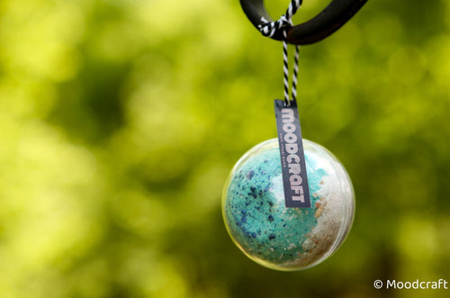 Moodcraft pendant with a blurred green background