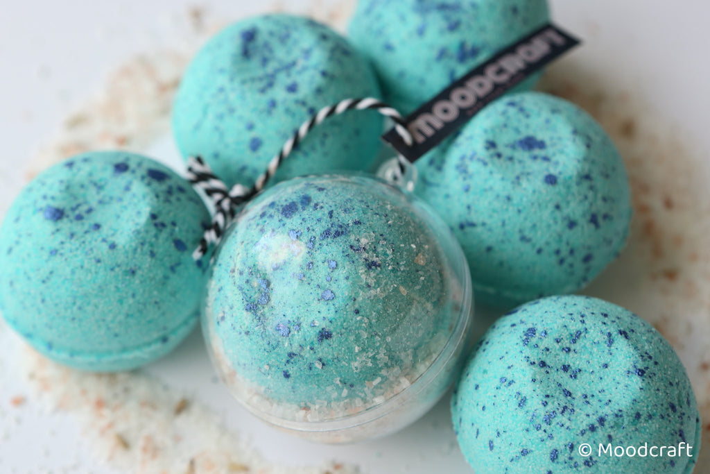 Turquoise bath bombs with speckles and a visible 'Moodcraft' label on a light background.